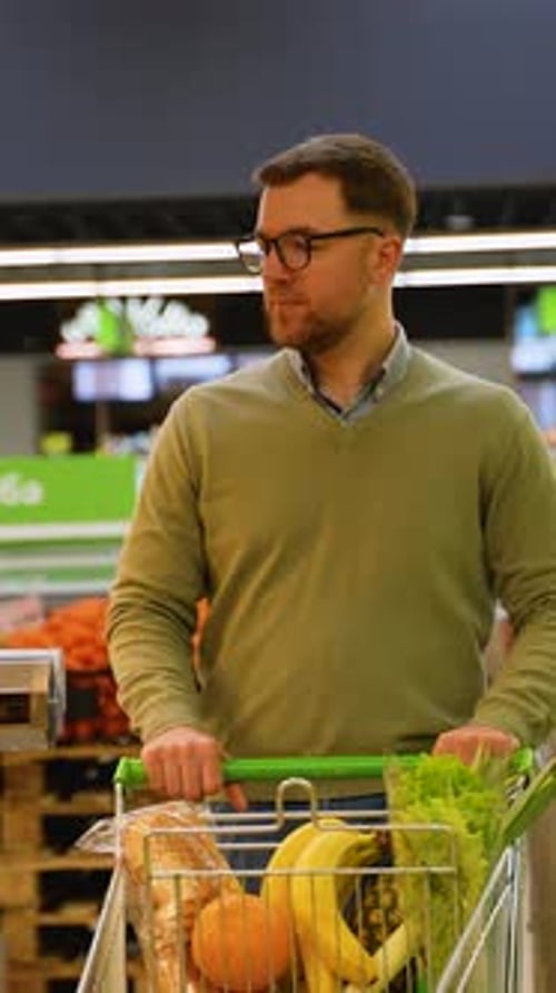 Man Grocery Shopping for Fresh Produce in Supermarket