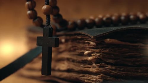 Wooden Rosary and Cross on Old Book