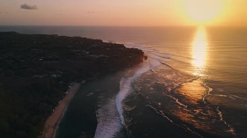 Coastline Landscape and Ocean Waves with Warm Sunset in Uluwatu Bali Aerial View