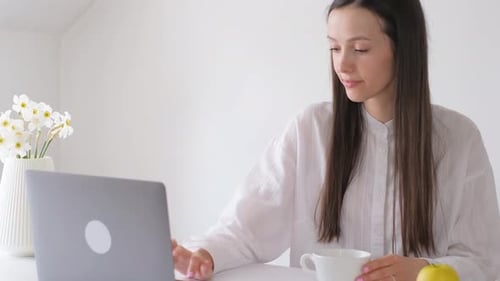 Woman Using Laptop at Table Indoors