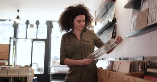 Young Adult female holding record in a store