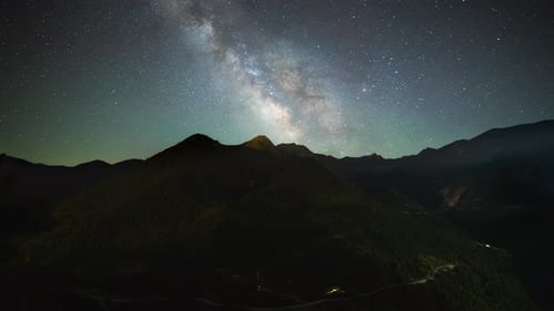 Colorful Milky way timelapse galaxy moving through the night sky over mountain peaks