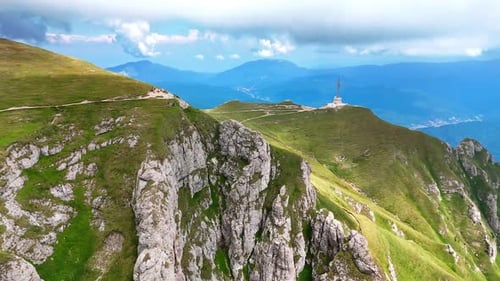 Flight above the grass-covered mountains with a cross monument.