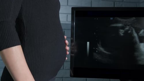 Une future maman avec le ventre contre l'écran