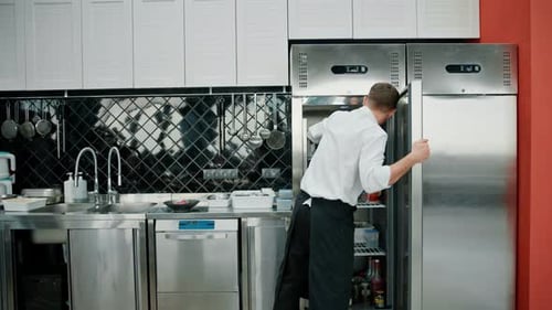 Chef Opening Refrigerator in Commercial Kitchen