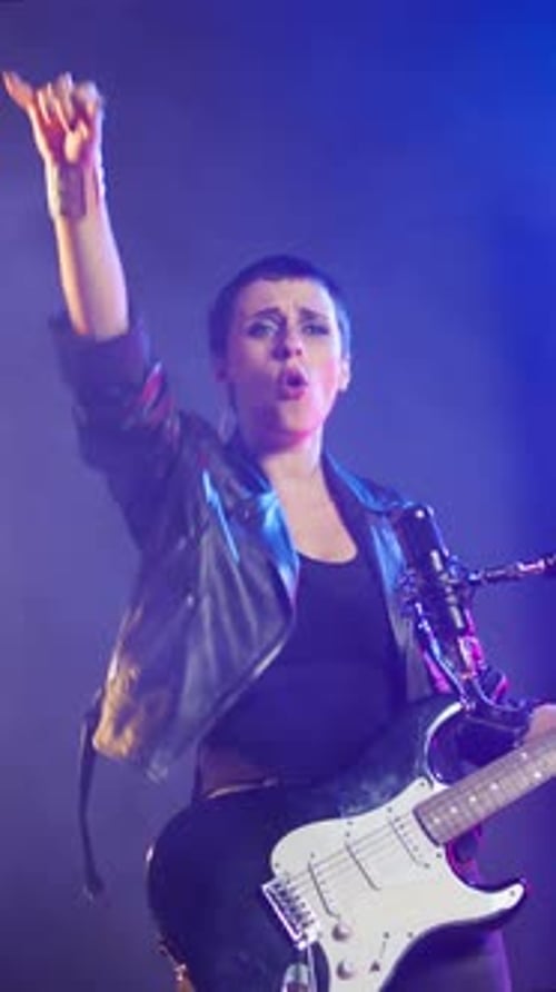 Vertical Video Punk Rock Girl with a Grunge Edgy Style Performing with a Bass Guitar