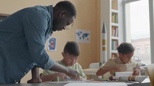 Teacher Assists Students with Craft Project in Classroom