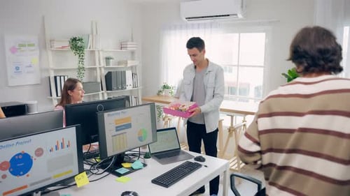 Group of businessman and woman eat donut while working in the office.