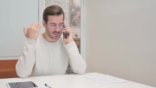 Middle Aged Man Talking on phone in Office
