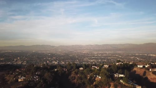 Drone flying over valley in Los Angeles, California at golden hour.