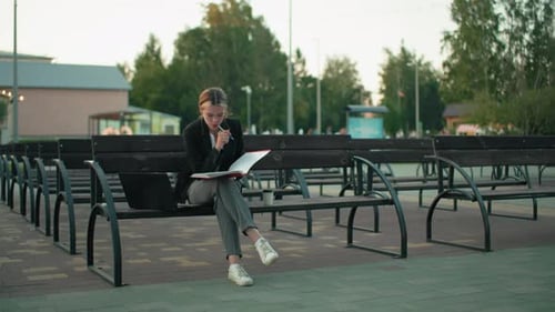 Woman Works on Bench Outdoors