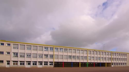 Shots of a School Facade Wide Shots Frame Movement of Clouds Over the Roof of a Modern Building