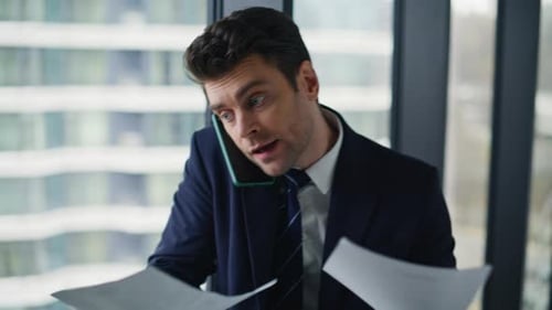 Businessman Talking on Phone and Throwing Papers