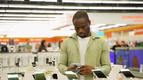 African American Customer Trying New Smartphone in Electronics Store