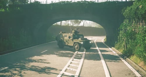 Military Vehicle Navigates a Serene Road Beneath a Lush Green Archway