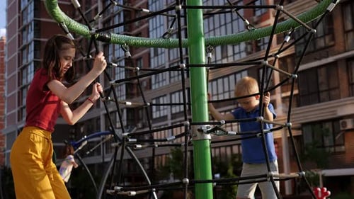 Children Climb the Grid on the Playground on a Hot Summer Day