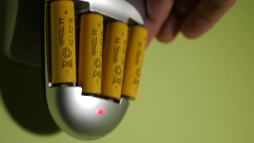72t. Der Vorgang des Ladens von Ni-Cd-Batterien vom Typ AA in einem Ladegerät, das an eine Steckdose angeschlossen ist
.