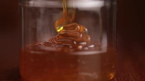 Honey being poured in a jar