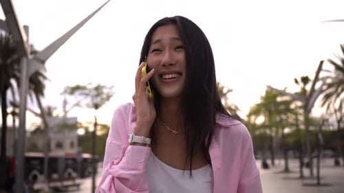 Young Woman Smiling and Talking on Mobile Phone