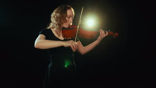 Woman Plays Violin in Dark Spotlight