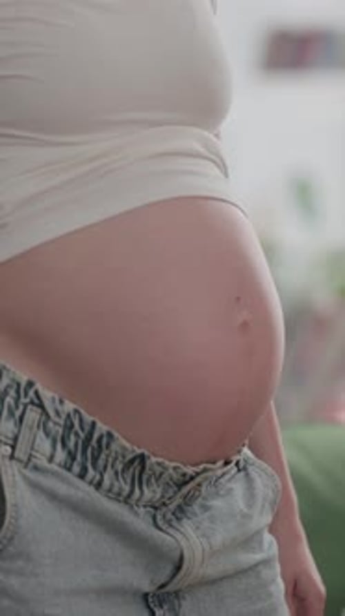 Mains masculines tenant le gros ventre d'une femme enceinte, vidéo verticale