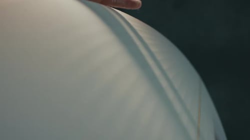 Surf factory. Adult male shaper creates the surfing board on the factory