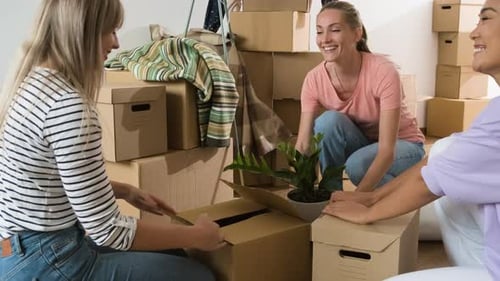 Young Adults Unpack Boxes Together in New Home