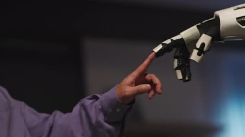 Man's Finger Touches Robotic Hand Forging Connection