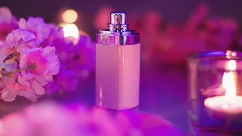 Composition de flacon de parfum rose avec fleurs et bougies. Vidéo du produit d'un parfum élégant