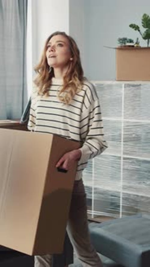 Young Couple Moving Out With Cardboard Box