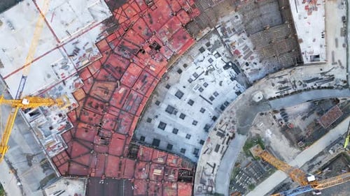 Luftbild von oben nach unten der Baustelle mit gelbem Kran und Baumaterial
