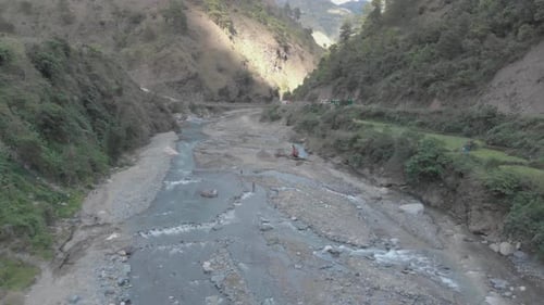 Rocky River Bed Bagger zieht Flussgestein für die Zementherstellung Brücke über Wasser in Val