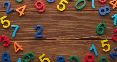Child Hand Puts Colored Numbers 2023 New Year on Wooden Background