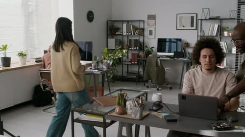 Girl Walking through Modern Office to Her Workplace and Pulling Chair out