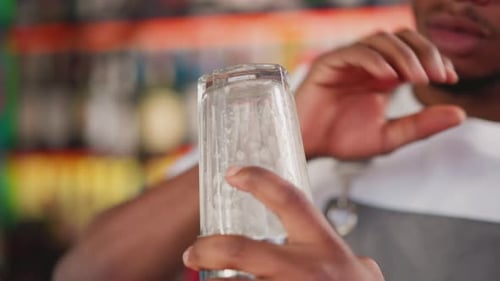 Barkeep Bumps Glass with Elbow in Bar
