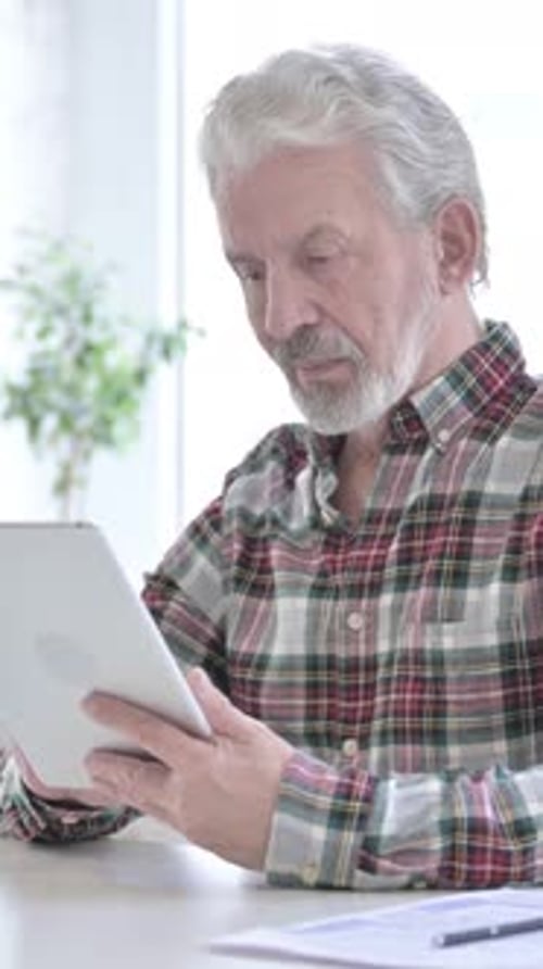 Hardworking Casual Old Man using Tablet in Office, vertical video