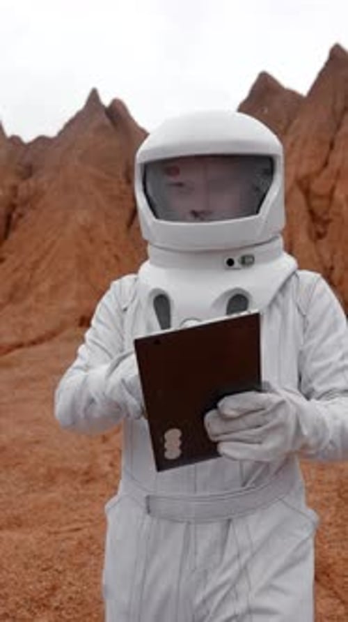 Vertical of Portrait of an Astronaut with Tablet in His Hands and a Special Protective Suit