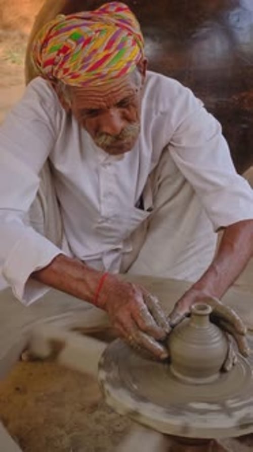Potier indien lançant un tour de potier et façonnant un pot en argile dans un atelier du Rajasthan, en Inde