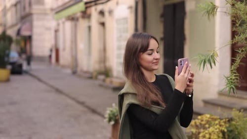 Young Woman Takes Pictures on City Street