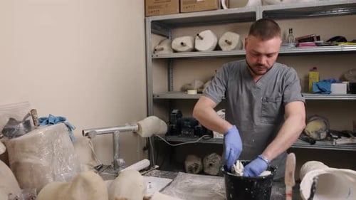 Man in Scrubs Prepares Material in Medical Workshop