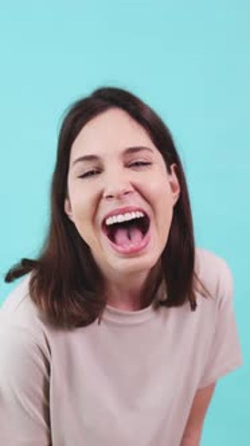 Young Woman Laughing on Turquoise Background