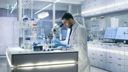 Scientist Works With Microscope in Bright Modern Lab