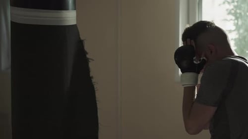 Boxer Hits Punching Bag By Hands in Sports Club