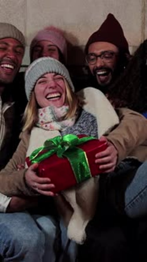Jeune femme adulte excitée verticale tenant un cadeau d'anniversaire ou un cadeau de Noël de ses meilleurs amis