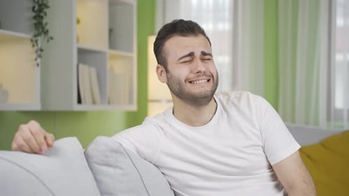 Depressed young man is crying, he has problems, he is upset.