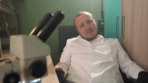 Scientist in Lab With Microscope in Foreground