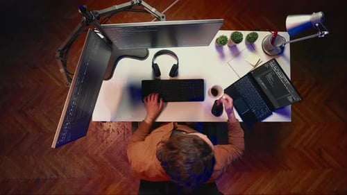 Top Down View of Engineer Developing PC Code Drinking Coffee Listening Music