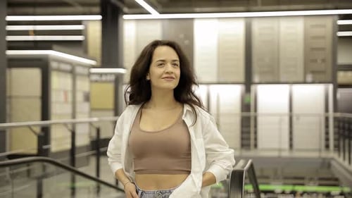 A Young Woman in a Store Chooses Wallpaper for Her Home Concept of Repair and Shopping