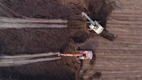 Excavators loading soil onto Trucks, Aerial view.