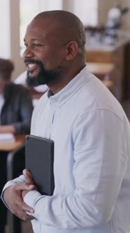 Face, smile and tablet male teacher in university classroom for assessment or examination